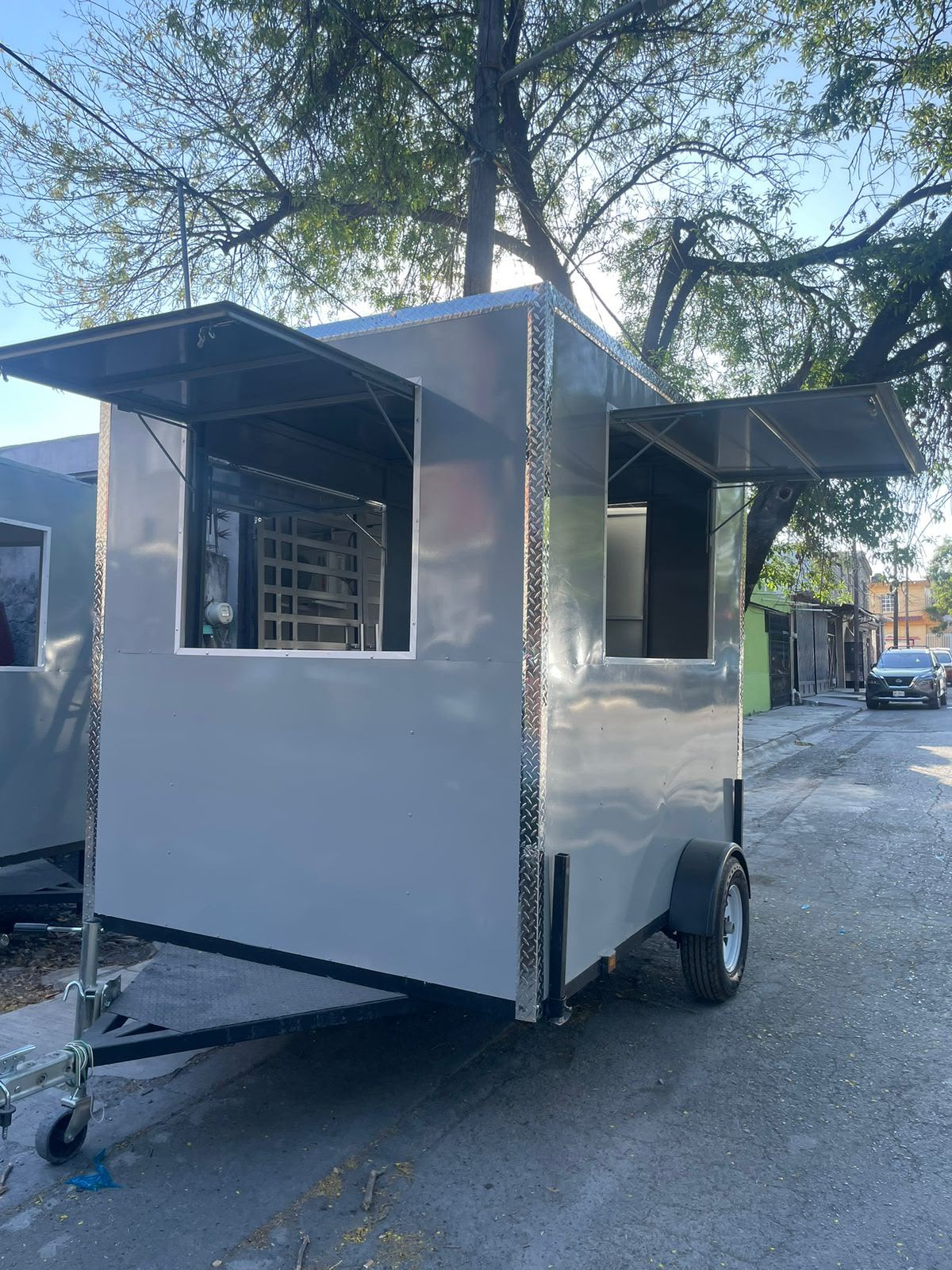 Remolque compacto plateado con doble ventana de servicio