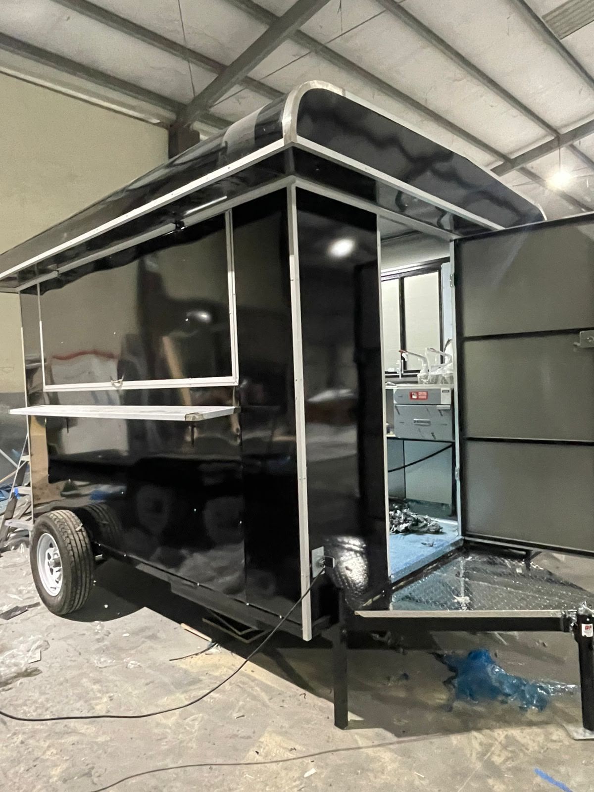 Remolque negro en taller Kavex con ventana de servicio y fregadero